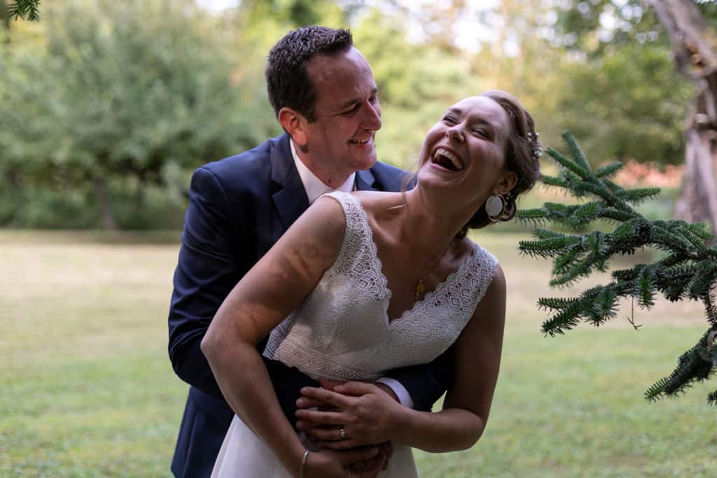Un couple de mariés rient. Photo en couleur. 