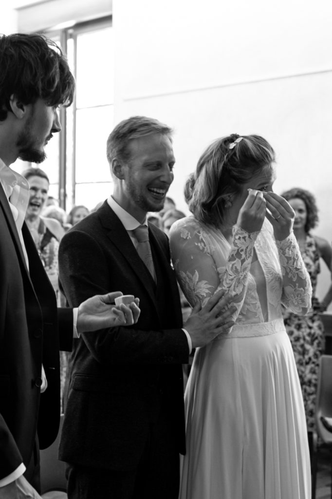 La mariée pleure et le marié rit pendant la cérémonie à la mairie. Mariage à Prébois, près de Grenoble, Région Rhône-Alpes. Photographie prise par Sabine Greppo, photographe de mariage à Lyon et en France. 