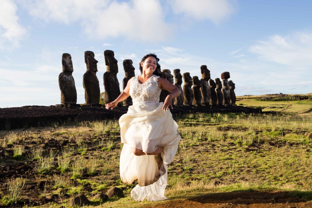 La mariée saute devant les statues moais, sur l'île de Pâques au Chili. Photographie par Sabine Greppo, photographe de mariage en France.